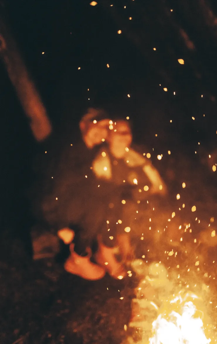 A bonfire with two blurred people in the background