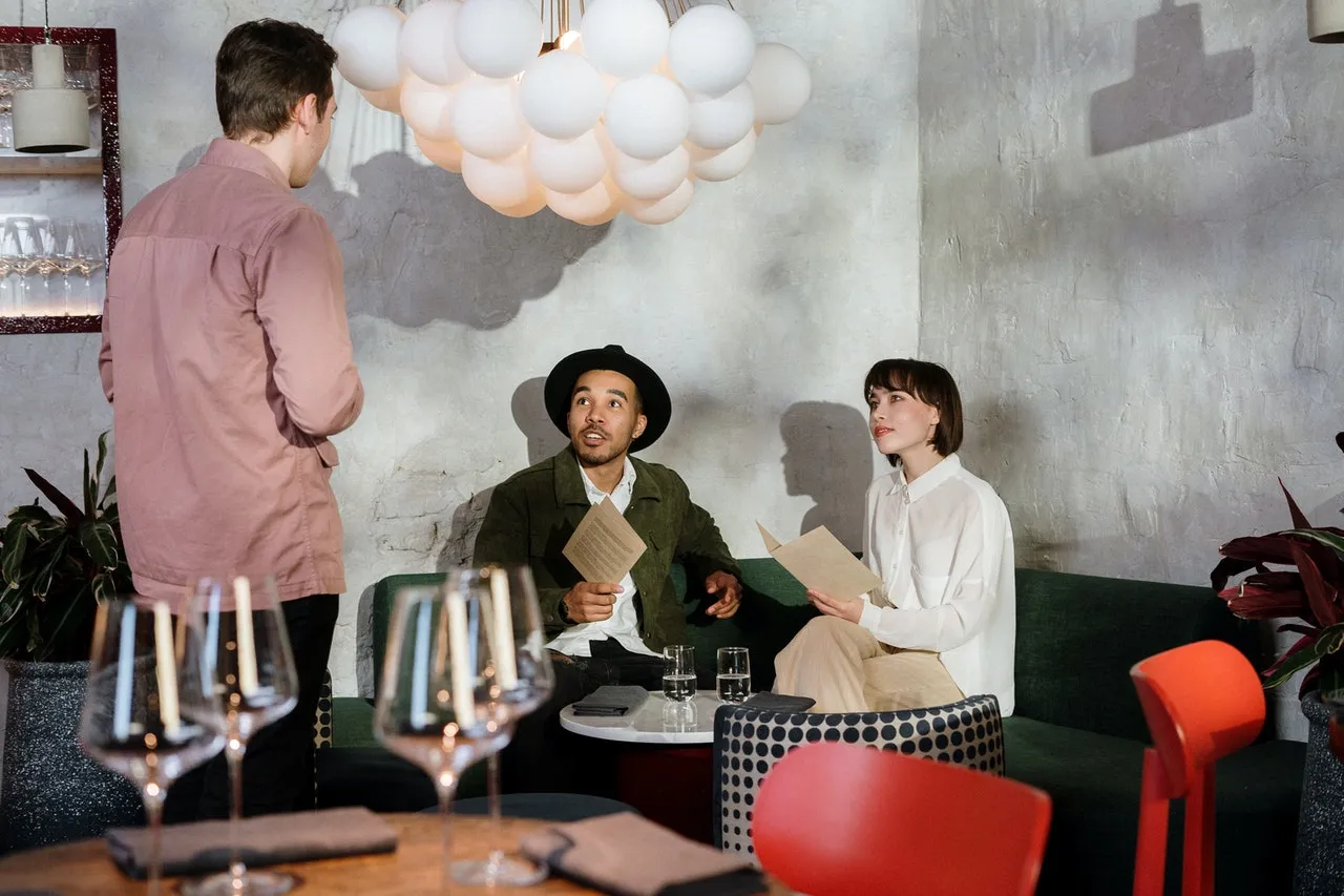 A couple meeting a man in a bar