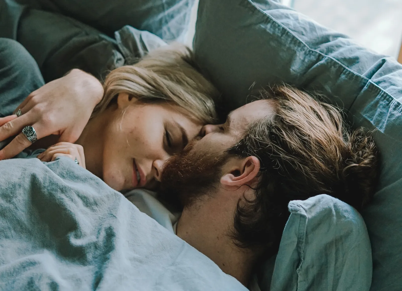 A couple cuddling in bed