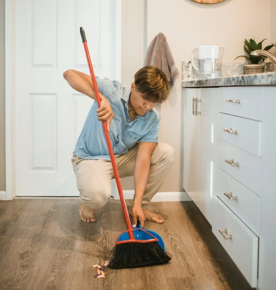 A man sweeping the kitchen
