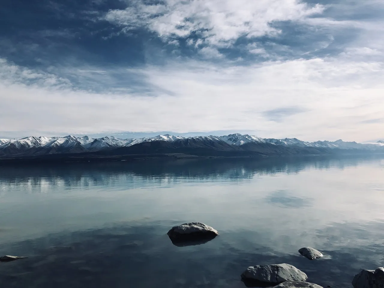 Calm water in front of a mountain